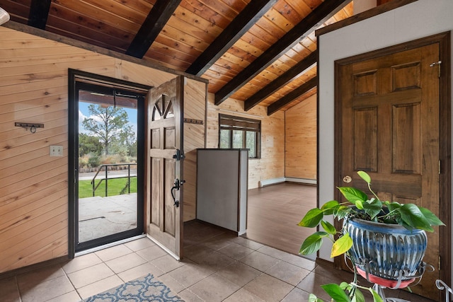 foyer with plenty of natural light, wooden walls, and vaulted ceiling with beams