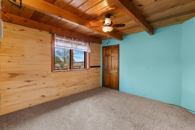 unfurnished room with carpet flooring, wood ceiling, wood walls, ceiling fan, and beam ceiling