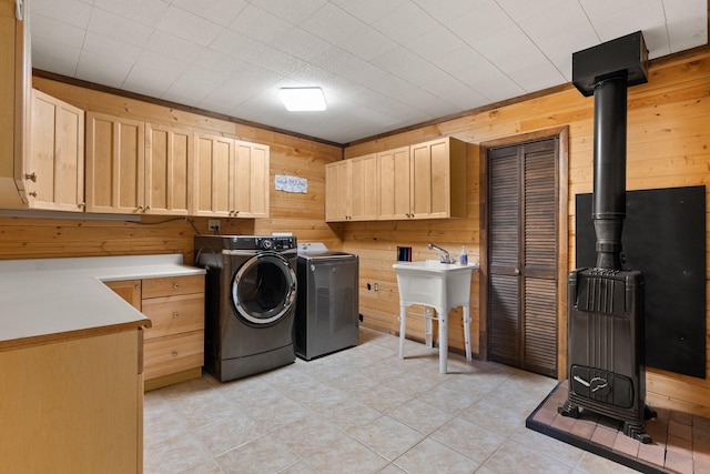 laundry area with wood walls, cabinets, sink, and independent washer and dryer