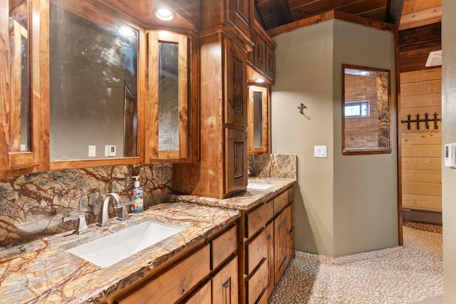 bathroom with tile patterned flooring, wooden walls, wooden ceiling, vanity, and backsplash