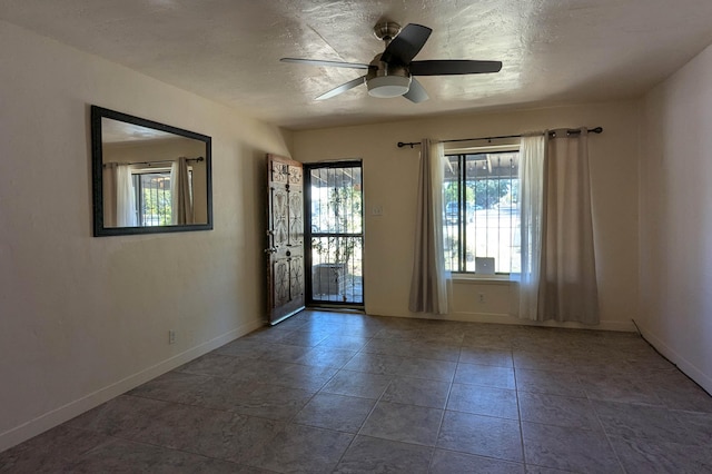 empty room featuring a healthy amount of sunlight, tile patterned flooring, and ceiling fan