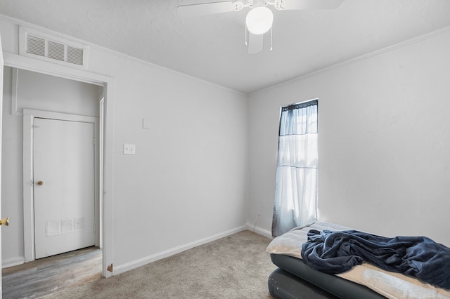 carpeted bedroom featuring crown molding and ceiling fan