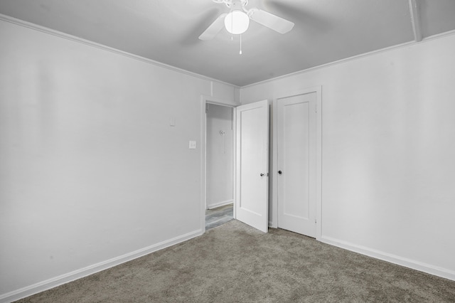 unfurnished bedroom with ornamental molding, carpet, and ceiling fan