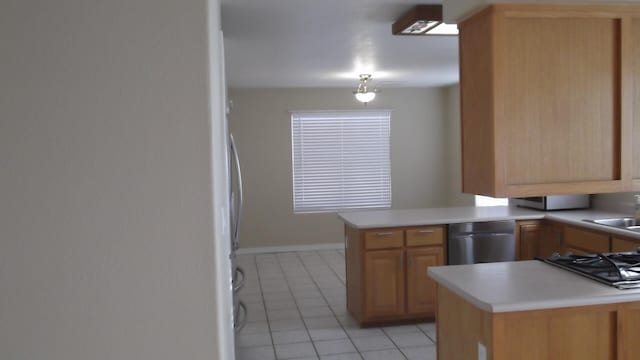 kitchen featuring white refrigerator, dishwasher, kitchen peninsula, gas stovetop, and light tile patterned floors