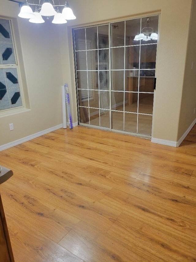 unfurnished dining area featuring hardwood / wood-style flooring and an inviting chandelier