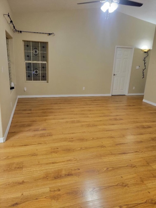 unfurnished room with light wood-type flooring, ceiling fan, and vaulted ceiling