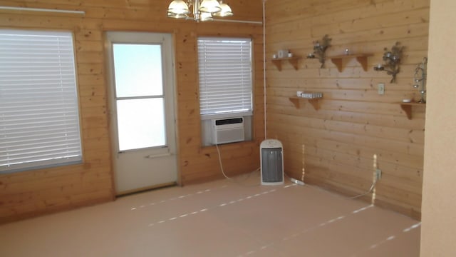 doorway with wood walls, cooling unit, and an inviting chandelier