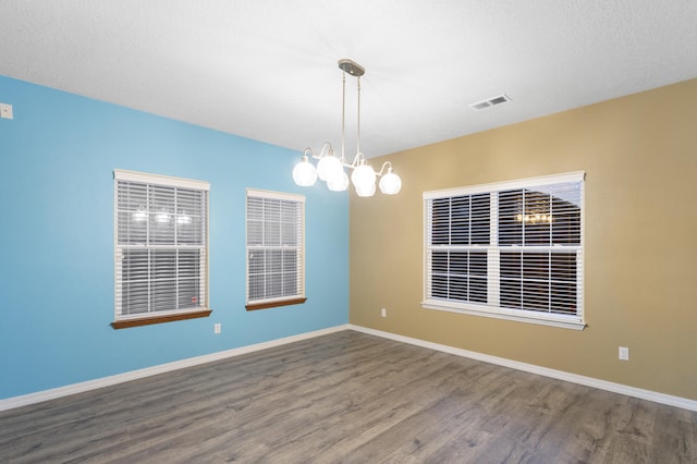 unfurnished room with hardwood / wood-style flooring and a textured ceiling