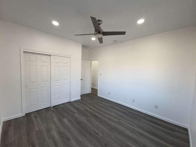 unfurnished bedroom with ceiling fan, a closet, and dark wood-type flooring