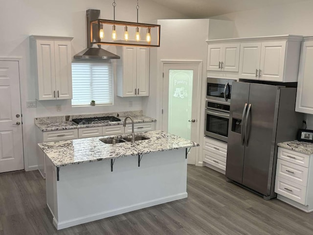 kitchen featuring appliances with stainless steel finishes, sink, exhaust hood, decorative light fixtures, and white cabinets