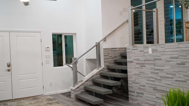 foyer featuring wood-type flooring and tile walls