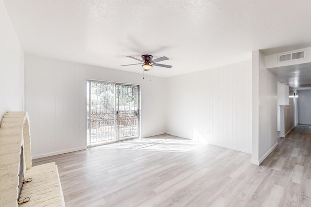 unfurnished living room with ceiling fan, light wood-type flooring, and a textured ceiling