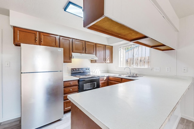 kitchen with light hardwood / wood-style floors, stainless steel fridge, range with electric stovetop, and sink