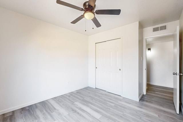 unfurnished bedroom featuring ceiling fan, light wood-type flooring, and a closet