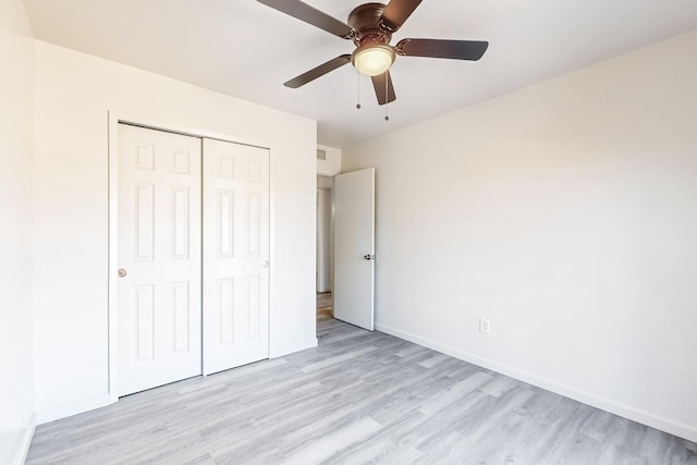 unfurnished bedroom with a closet, light hardwood / wood-style flooring, and ceiling fan