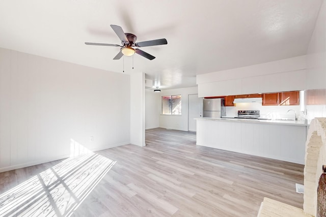 unfurnished living room with ceiling fan, light wood-type flooring, and sink