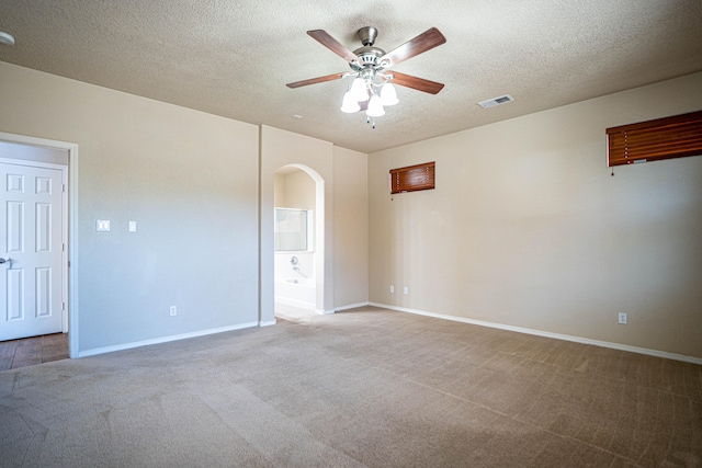 carpeted spare room featuring a textured ceiling and ceiling fan