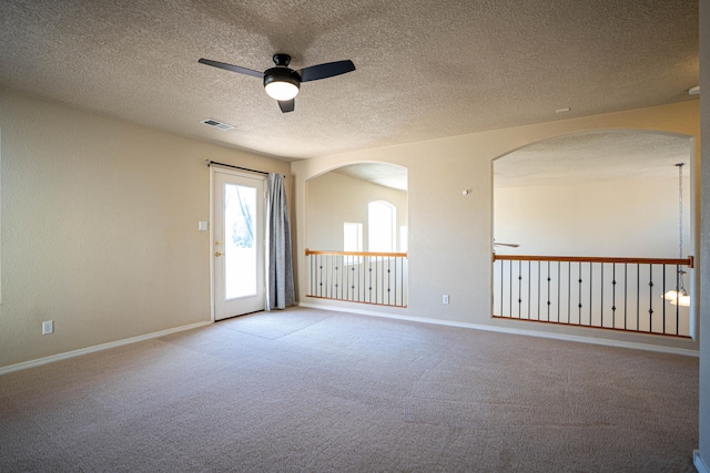 carpeted empty room with ceiling fan and a textured ceiling