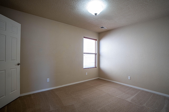 carpeted spare room with a textured ceiling