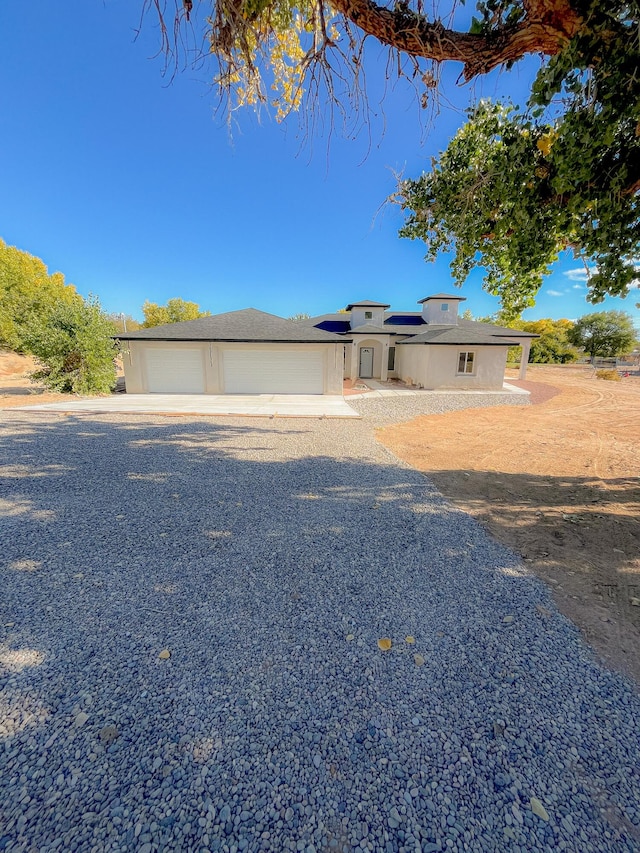 view of front of house featuring solar panels and a garage