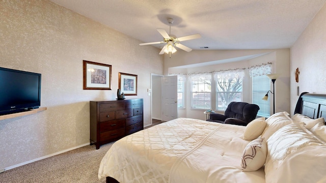 bedroom with lofted ceiling, a textured ceiling, light colored carpet, and ceiling fan