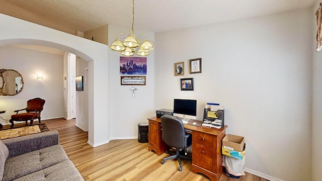 office featuring a textured ceiling, light hardwood / wood-style flooring, and an inviting chandelier