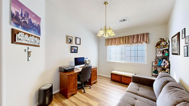 office featuring an inviting chandelier, light hardwood / wood-style flooring, a textured ceiling, and vaulted ceiling