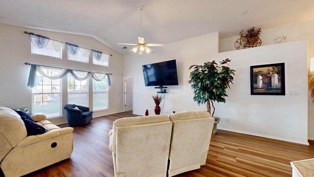 living room featuring hardwood / wood-style flooring, ceiling fan, and vaulted ceiling