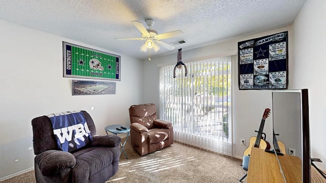 living area featuring carpet, a textured ceiling, and ceiling fan