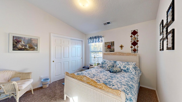 bedroom with a closet, a textured ceiling, carpet flooring, and vaulted ceiling