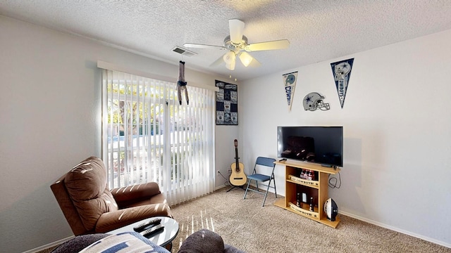 living room featuring a textured ceiling, carpet flooring, and ceiling fan