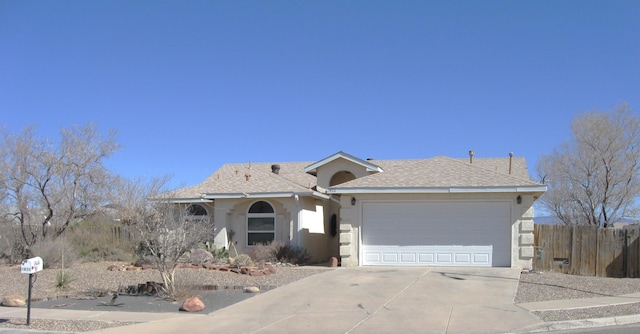 single story home with a shingled roof, concrete driveway, an attached garage, fence, and stucco siding