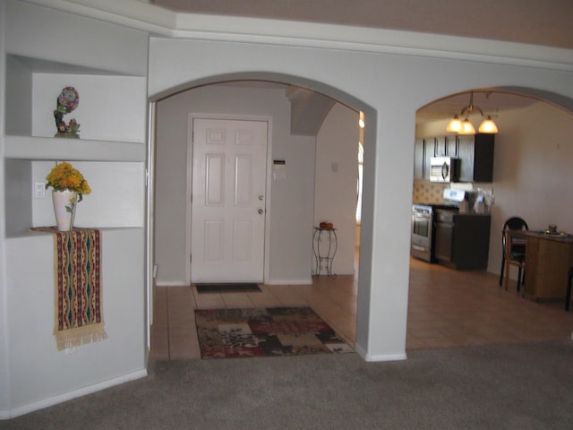 carpeted foyer with arched walkways