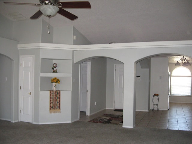 interior space with high vaulted ceiling, tile patterned flooring, ceiling fan, and arched walkways