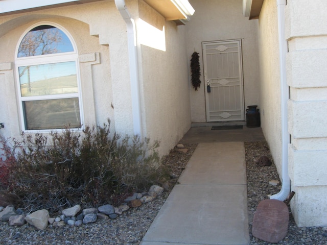 entrance to property featuring stucco siding