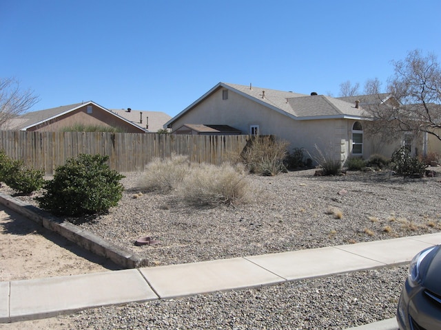 view of home's exterior with fence and stucco siding