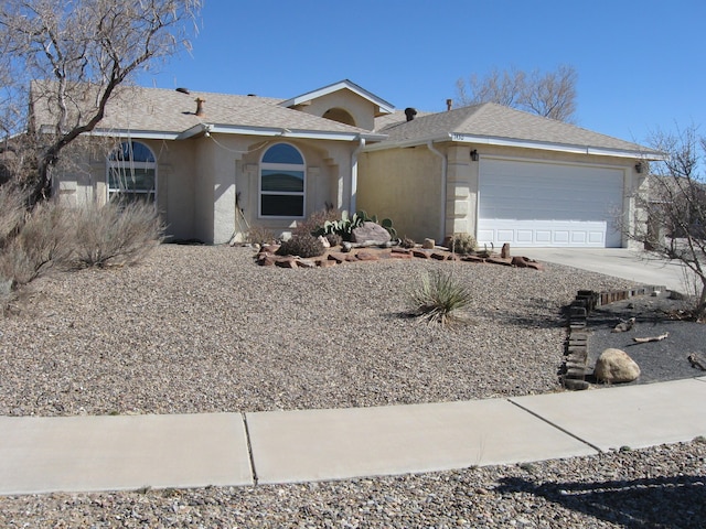 single story home featuring roof with shingles, driveway, an attached garage, and stucco siding