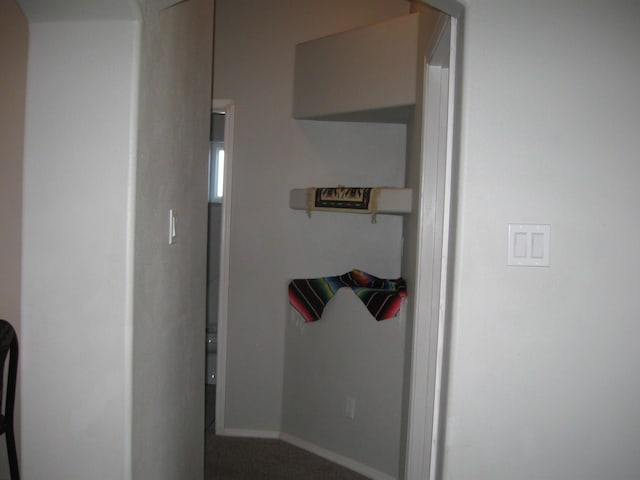 hallway with carpet floors and baseboards