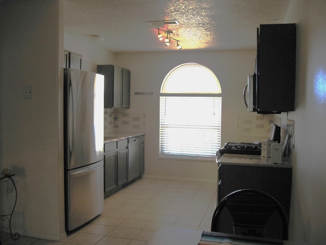 kitchen with light tile patterned floors, gray cabinets, light countertops, visible vents, and appliances with stainless steel finishes