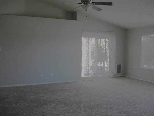 spare room with lofted ceiling, visible vents, ceiling fan, and carpet flooring