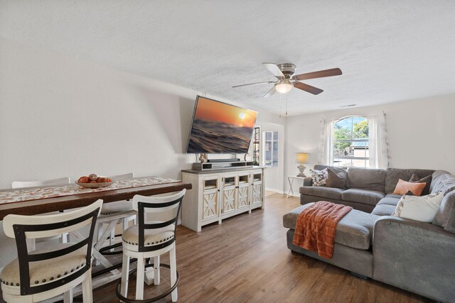 living room with ceiling fan, hardwood / wood-style floors, and a textured ceiling