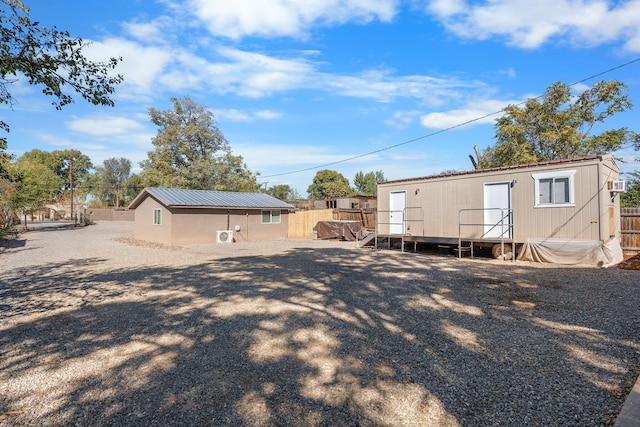 back of house with fence and metal roof