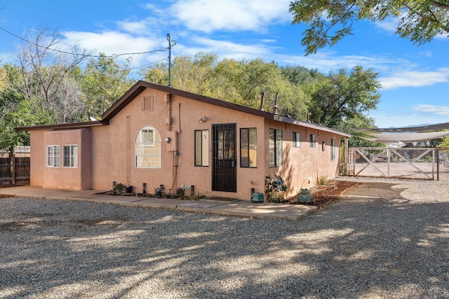 view of front of property featuring a gate, fence, and stucco siding