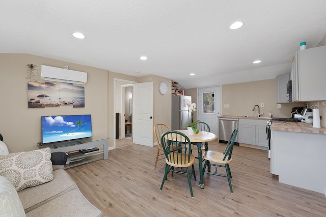 dining area featuring baseboards, light wood finished floors, a wall mounted air conditioner, and recessed lighting