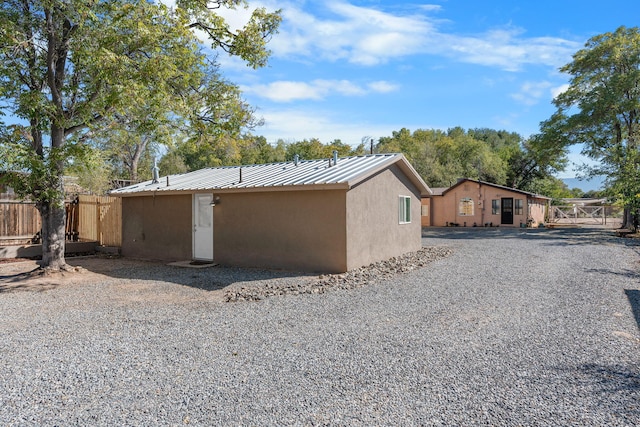 view of home's exterior with metal roof, fence, and stucco siding