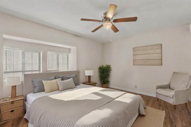 bedroom with dark wood-style floors, ceiling fan, and baseboards