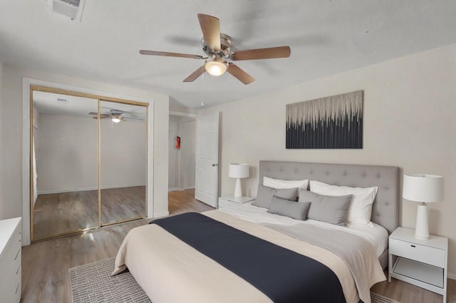 bedroom featuring a closet, visible vents, light wood-style floors, a ceiling fan, and baseboards