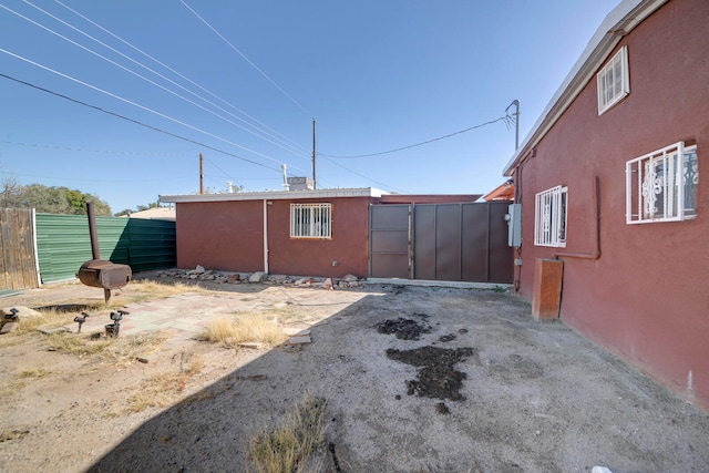 view of property exterior featuring a storage unit and a patio area