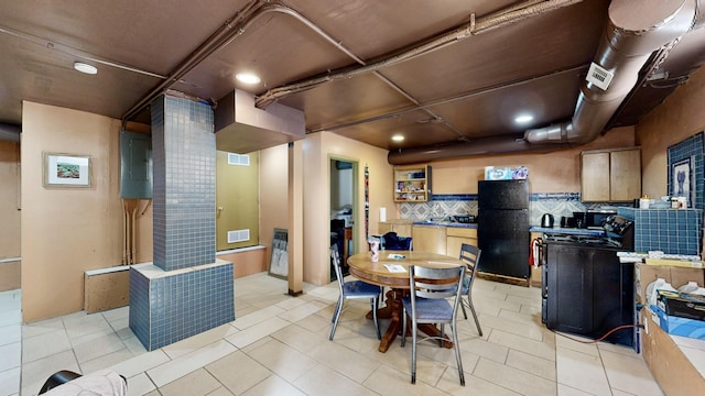 kitchen with freestanding refrigerator, visible vents, range with electric cooktop, and ornate columns