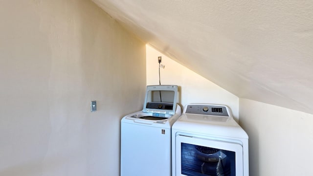 clothes washing area featuring laundry area, a textured ceiling, and washer and dryer